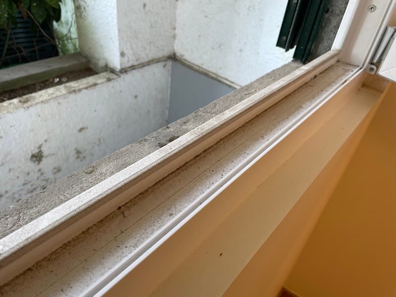 Caixilho de janela com acumulação de pó de obras